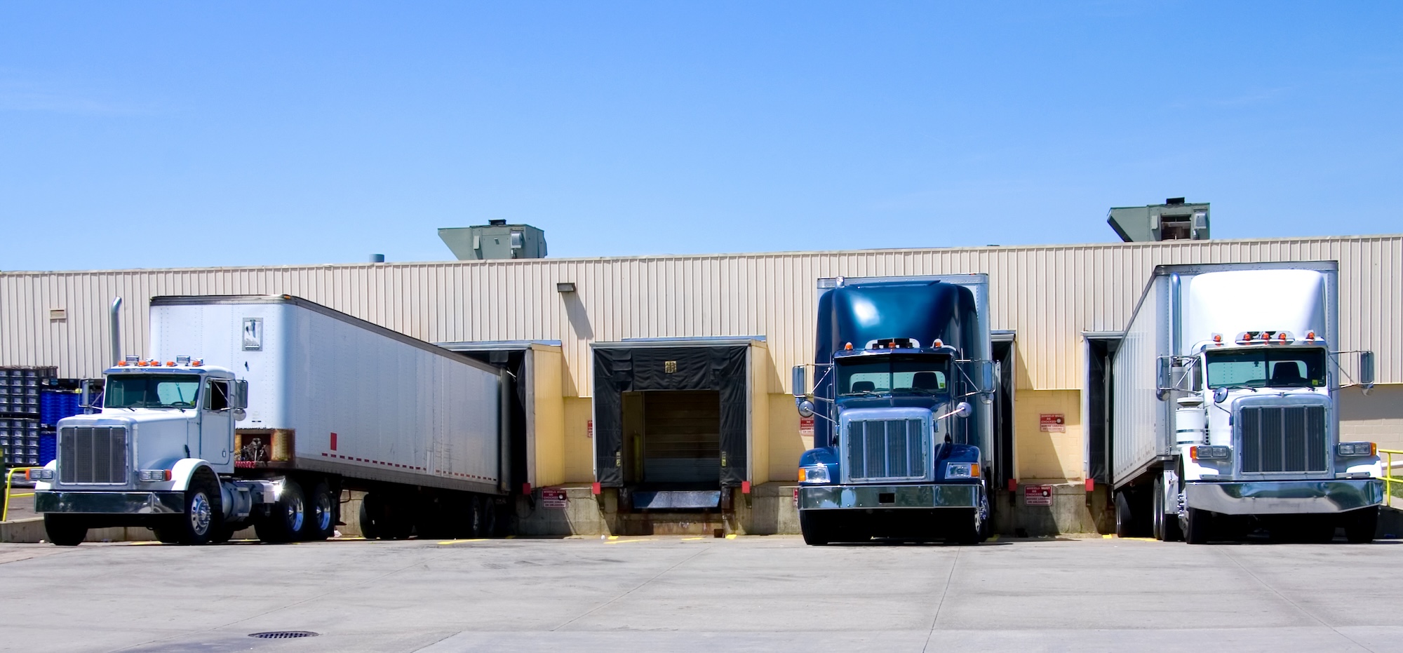 Complete Warehouse Providers - 18 wheeler semi trucks loading at a warehouse building